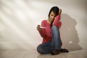 sad woman looking at pregnancy test